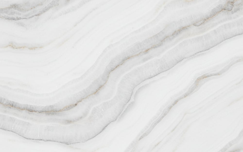 Thunder White quartzite — polished slab surface showing White coloring. Origin: Brazil. Hardness: 7 Mohs. Acid sensitivity: none.