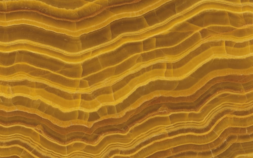 Tiger Onyx onyx — polished slab surface showing Gold/Yellow coloring. Origin: Turkey. Hardness: 3 Mohs. Acid sensitivity: high.
