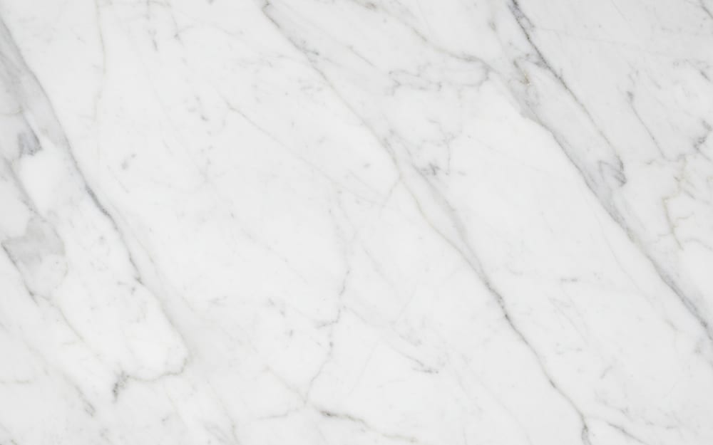Turkish Carrara marble — polished slab surface showing White coloring. Origin: Turkey. Hardness: 3 Mohs. Acid sensitivity: high.