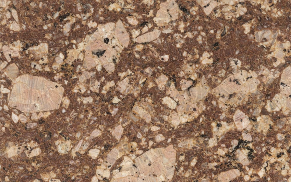 Typhoon Bordeaux granite — polished slab surface showing Brown coloring. Origin: Brazil. Hardness: 6 Mohs. Acid sensitivity: none.