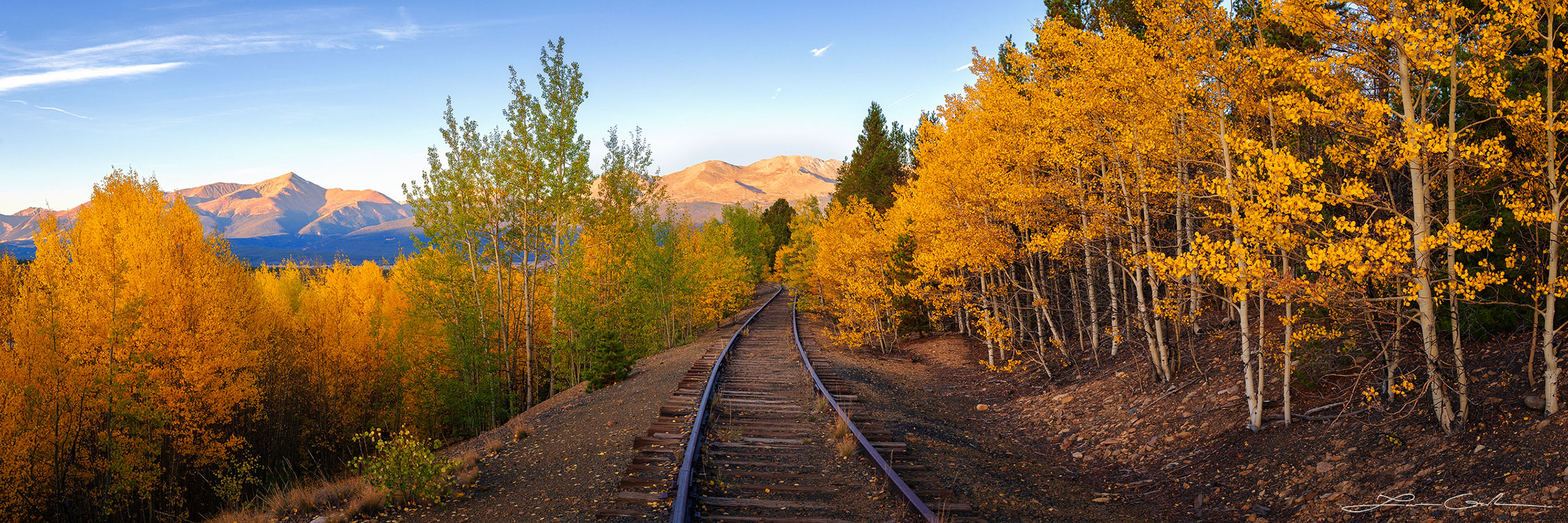 autumn train through colorful forest mountains