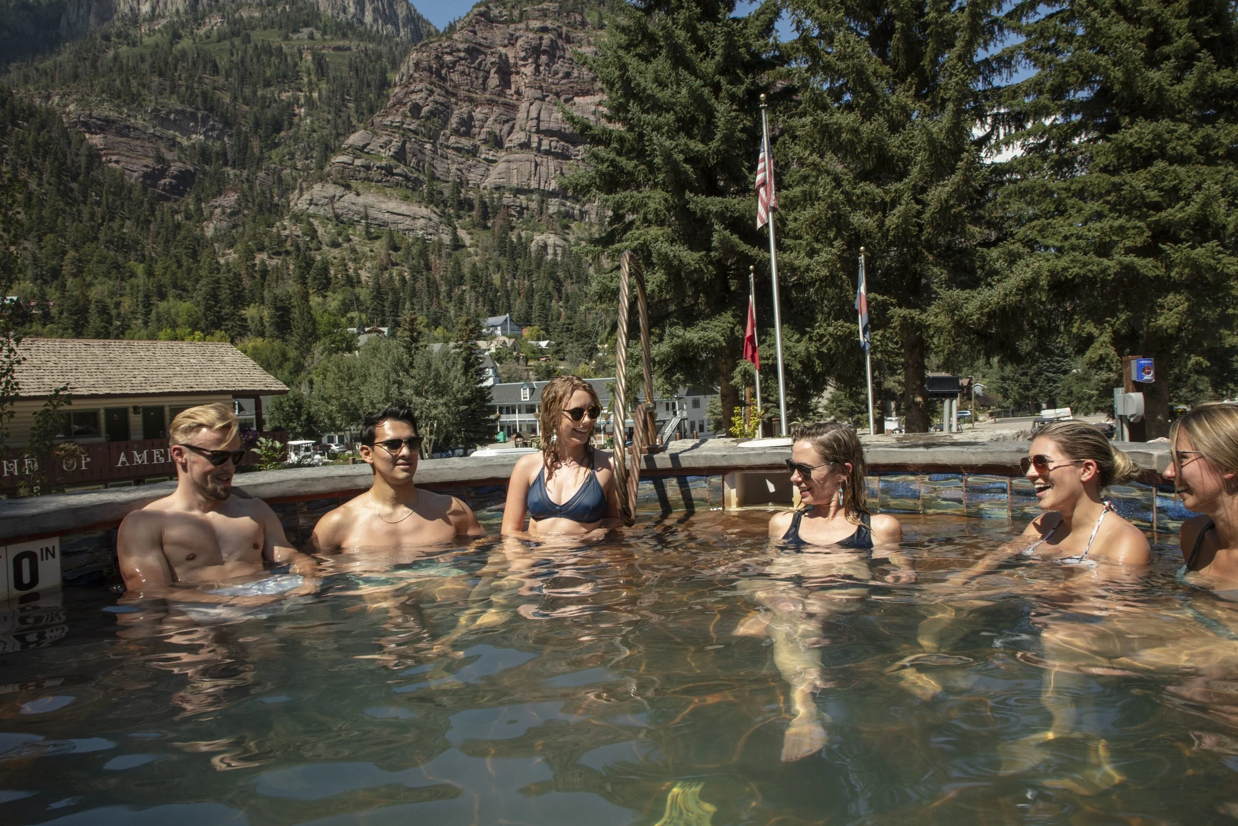 family soaking in outdoor hot springs winter mountain setting