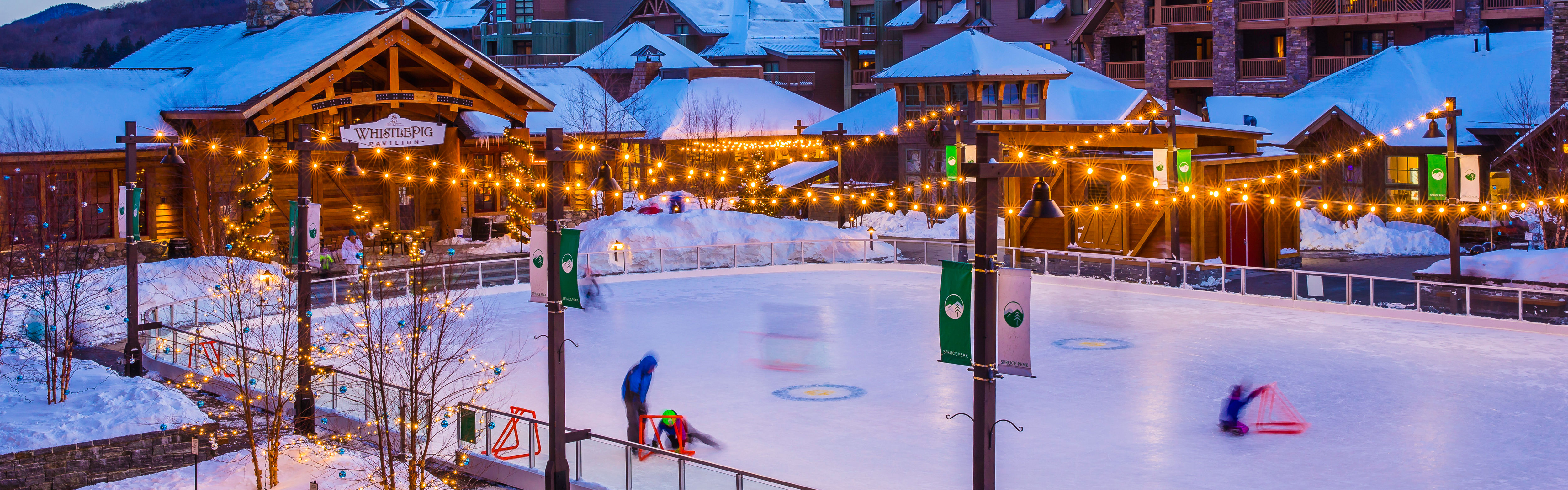 mountain resort ice skating rink with snow covered peaks