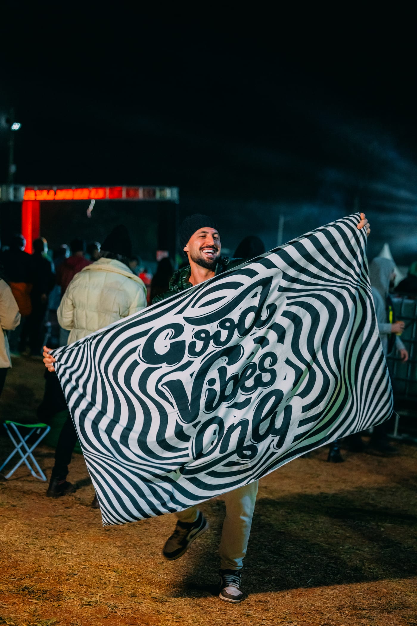 Participante com bandeira Good Vibes Only, transmitindo toda a energia positiva e vibe do evento