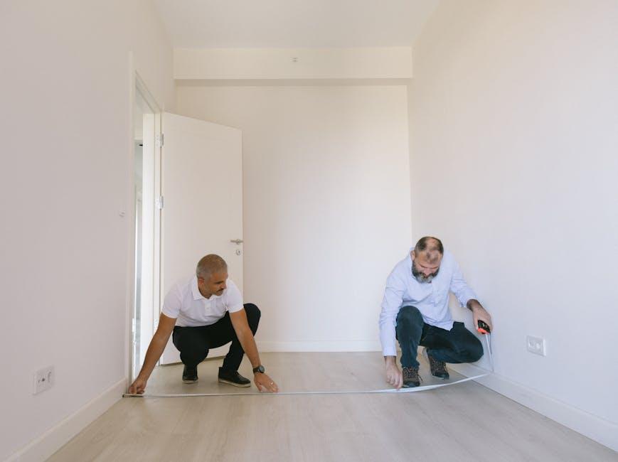 Couple measuring space in their new smaller apartment before move-in