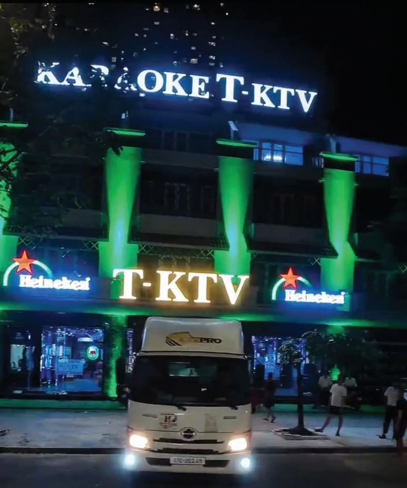 Mặt tiền T-KTV với cột sáng xanh neon và biển hiệu chữ nổi