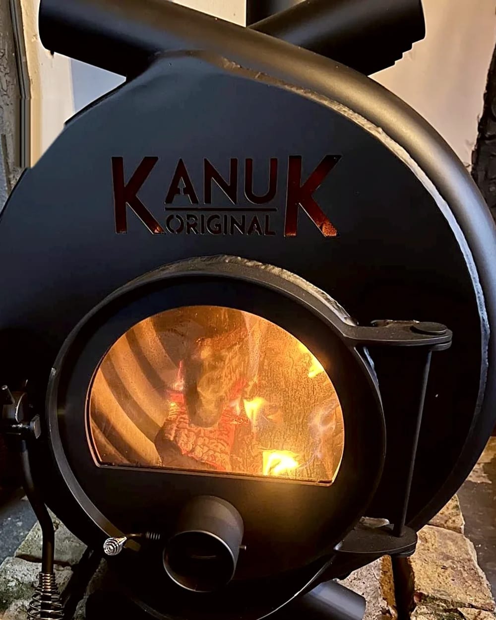 Kanuk-Holzofen mit loderndem Feuer – die beheizte Scheune, auch im Winter behaglich warm