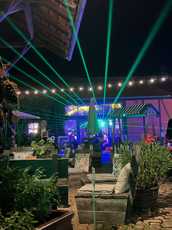 Abendstimmung mit Lichterketten und Lasershow im Innenhof