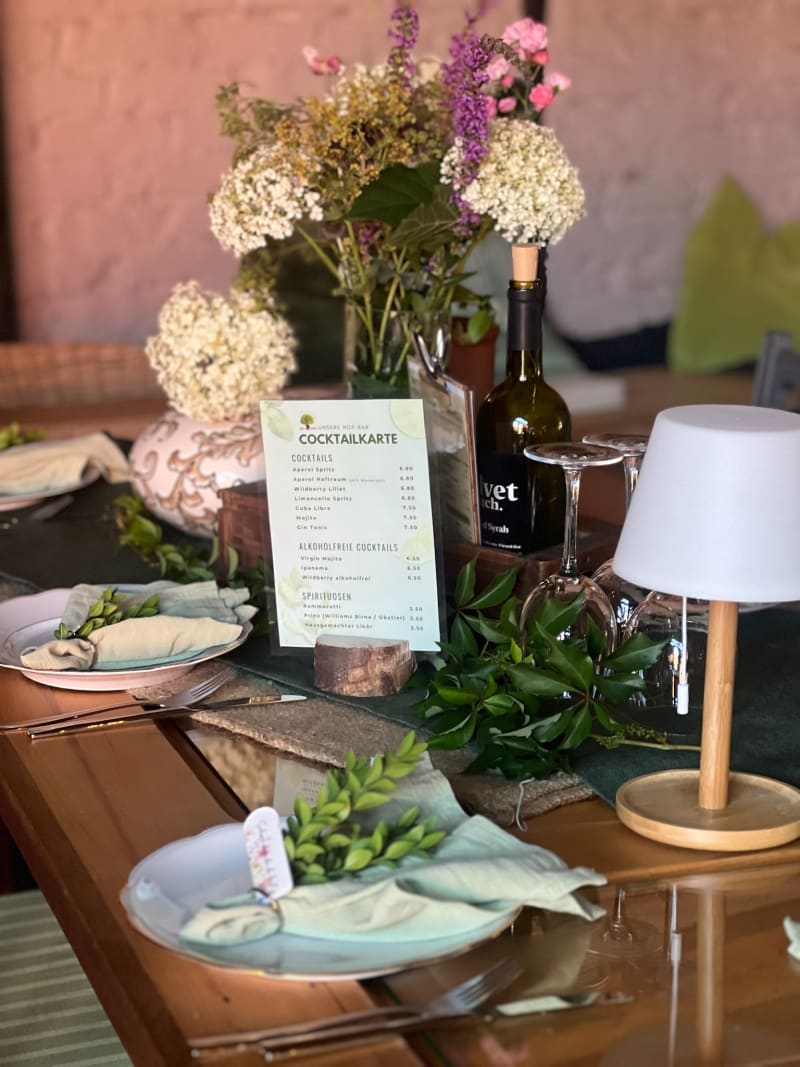 Festlich gedeckte Tafel mit Blumen und Hof-Bar-Cocktailkarte