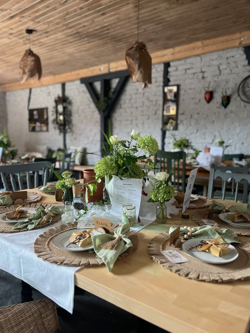 Festlich gedeckte Tafel in der Scheune – Detail mit Blumen und Gedeck