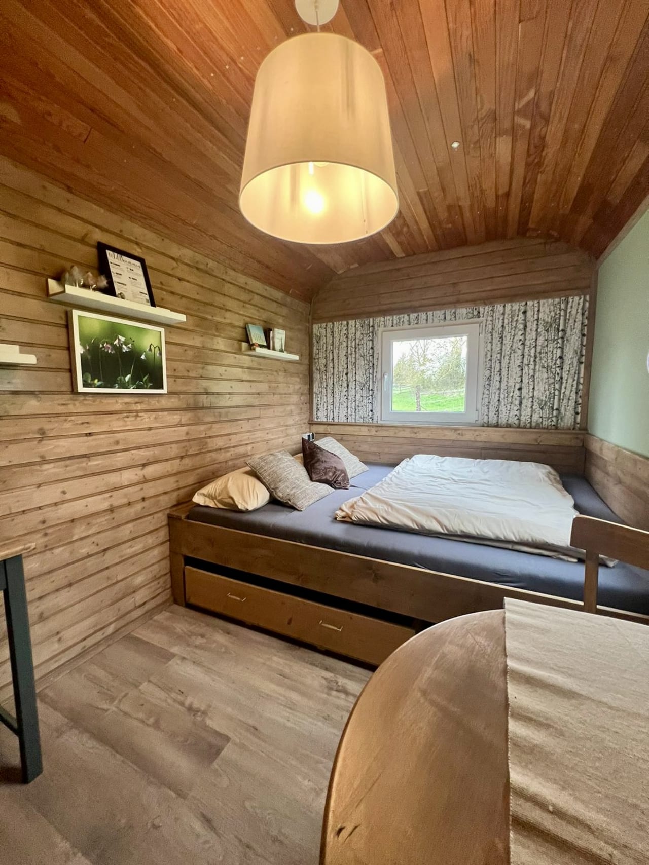 Café-Bereich im Bauwagen mit Holz-Wänden und Blumen