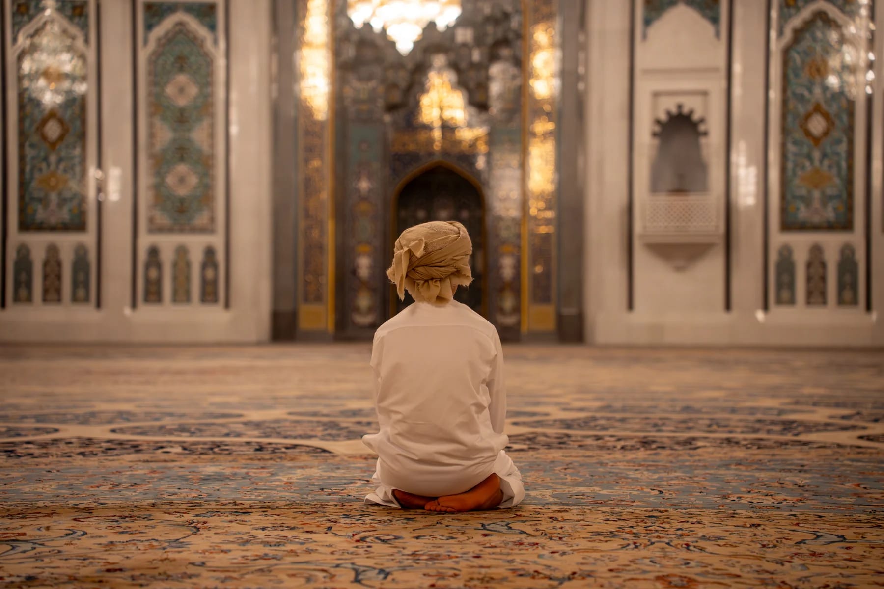Child praying inside Sultan Qaboos Grand Mosque