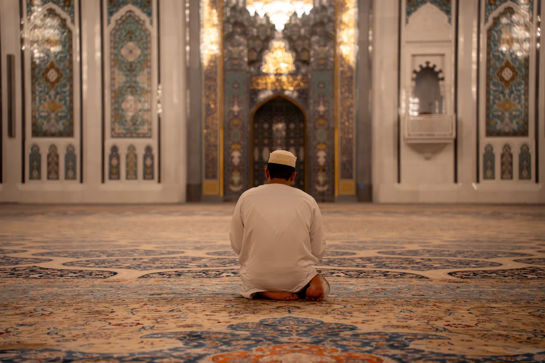 Man praying in Sultan Qaboos Grand Mosque