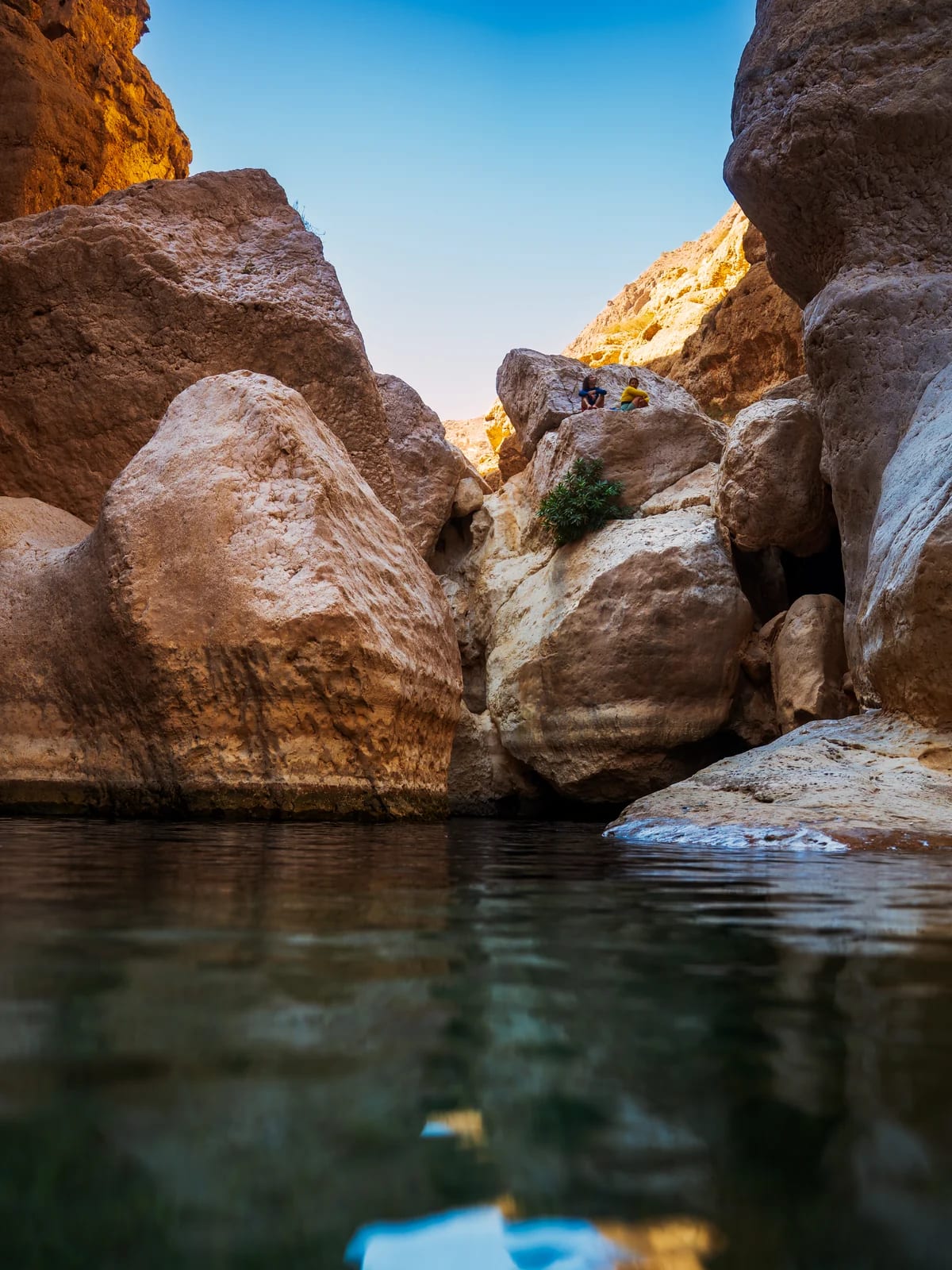 Clear Wadi Shab water with rock textures