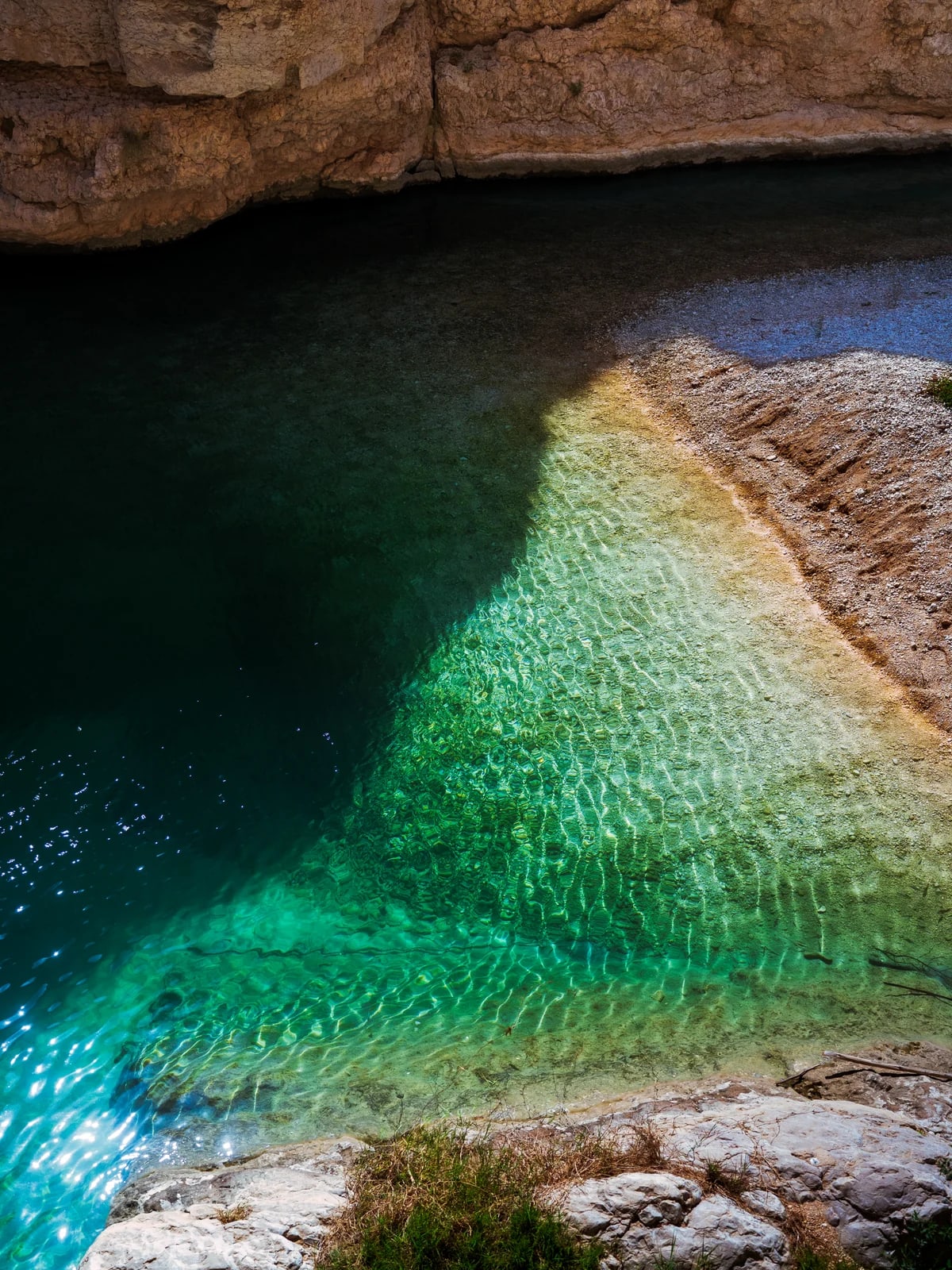 Turquoise Wadi Shab water pool between canyon walls