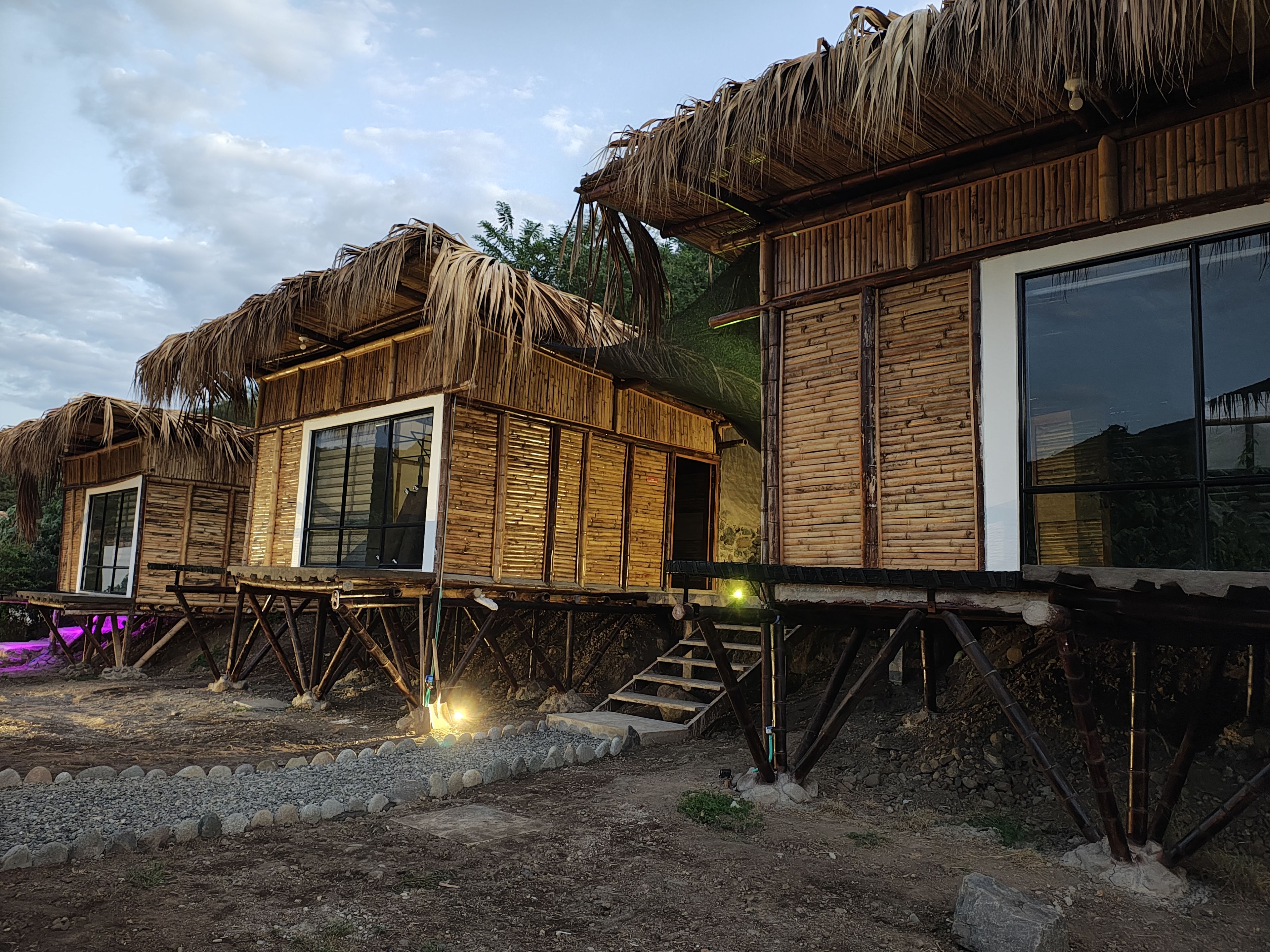 Vista exterior de los refugios Suite Familiar con construcción de bambú y techo de paja