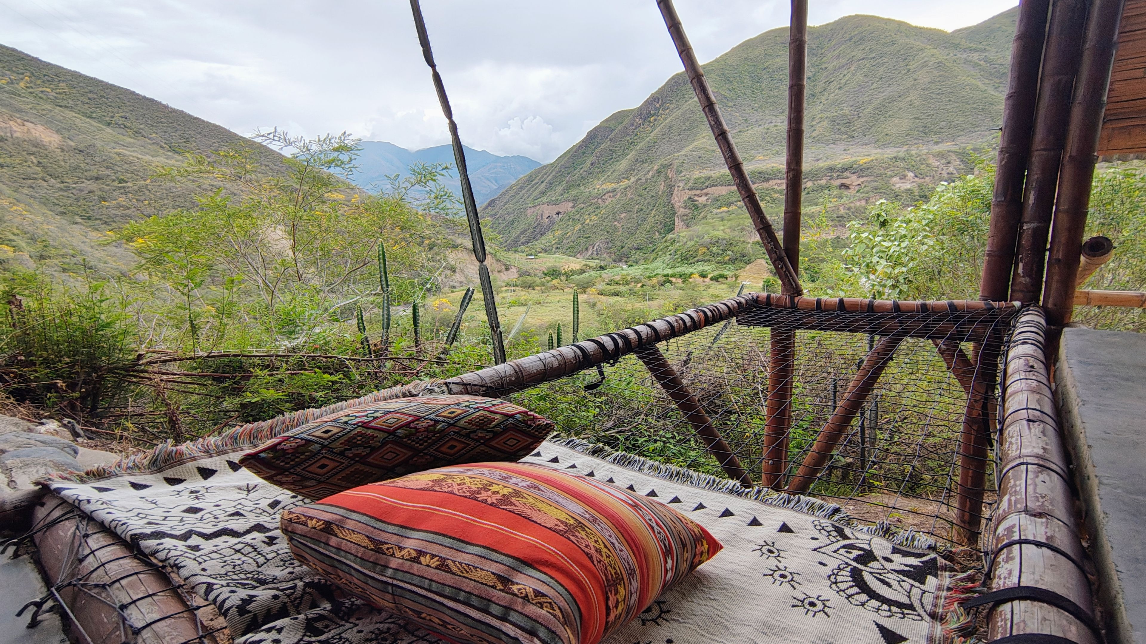 Terraza privada con cojines artesanales y vista panorámica a las montañas