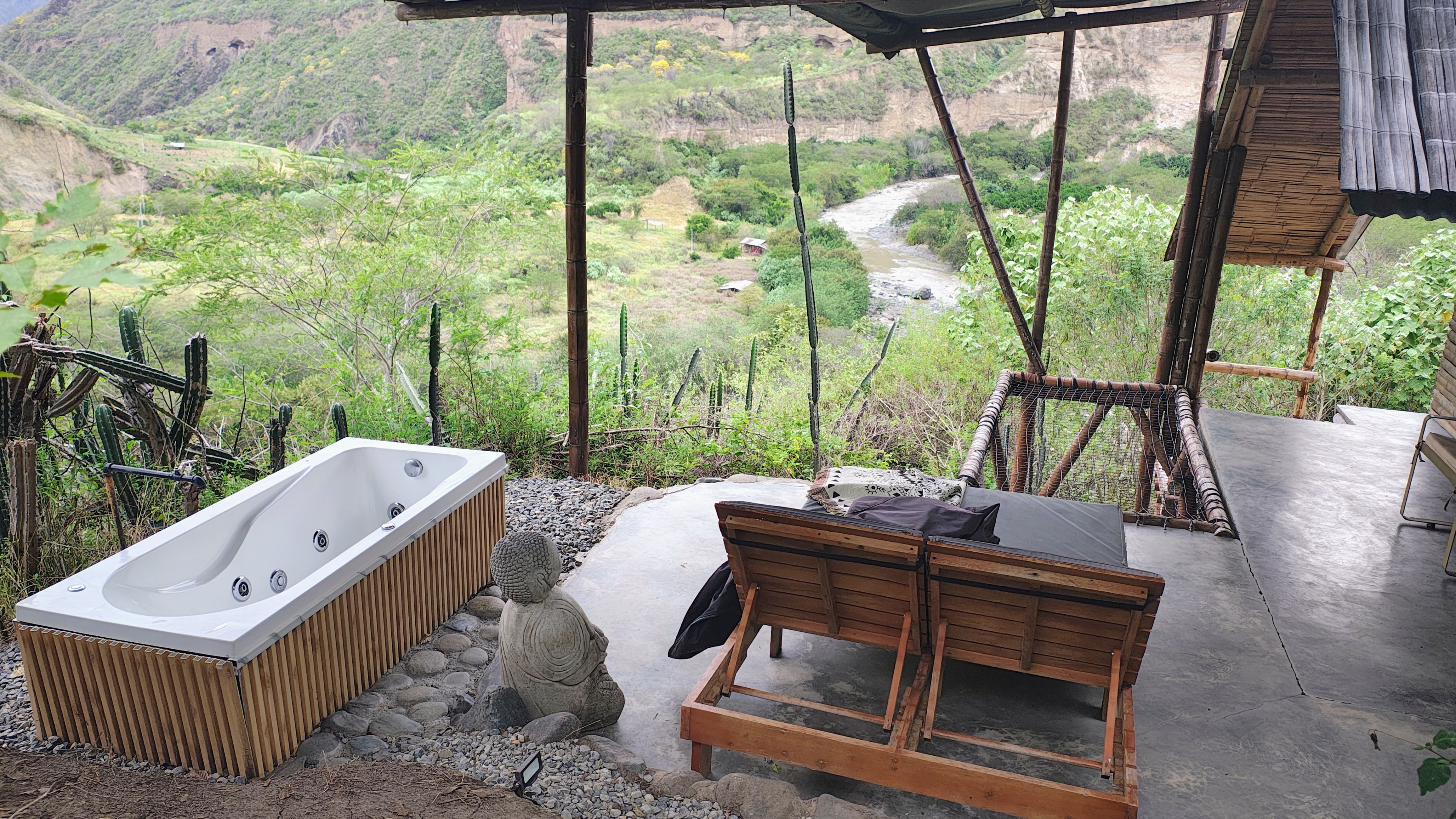 Tina de hidromasaje en terraza privada con vista al río y las montañas