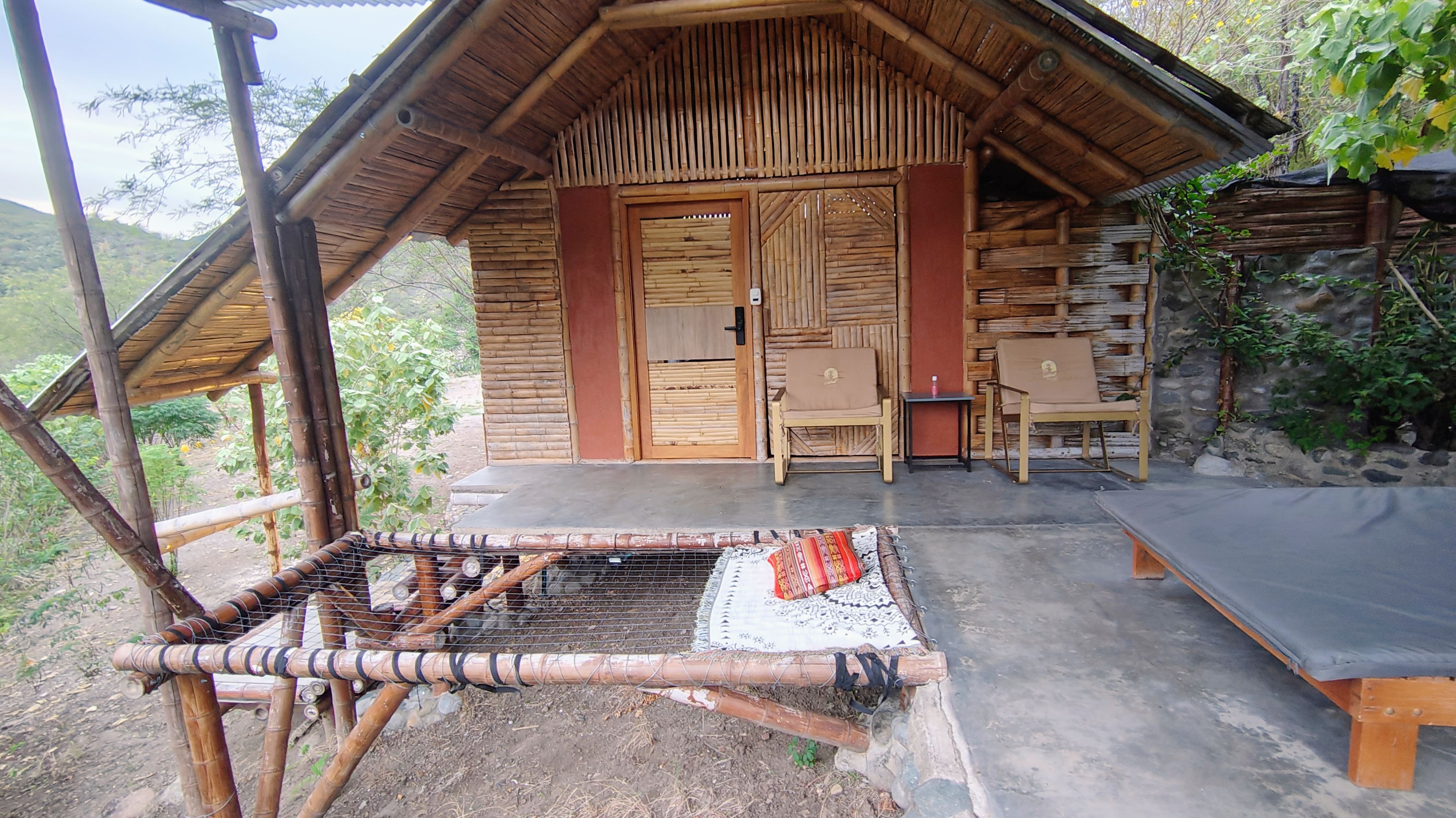 Fachada exterior de la Suite Río con entrada de bambú y cama red para ver las estrellas