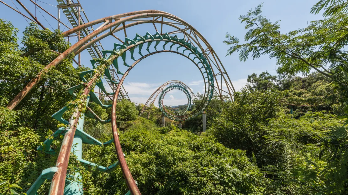 The ruins of a roller coaster in an abandoned theme park in Japan photographed by Romain Veillon in a series of photos of abandoned places overtaken by nature.