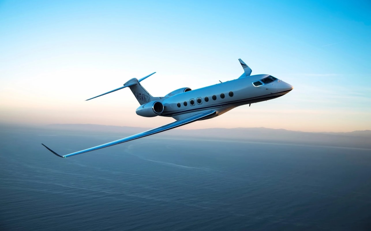 Private jet flying above clouds at dusk