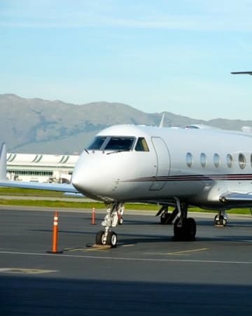 Private jet on airport tarmac with mountains