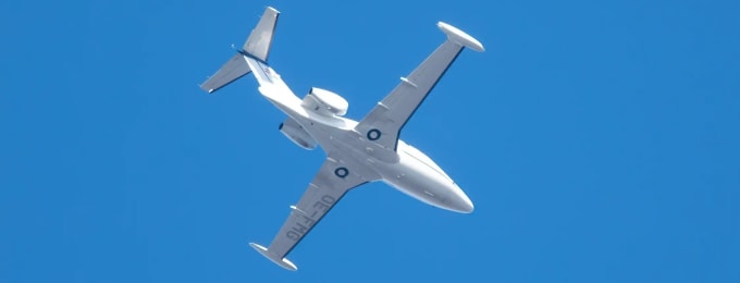 Private jet flying in clear blue sky