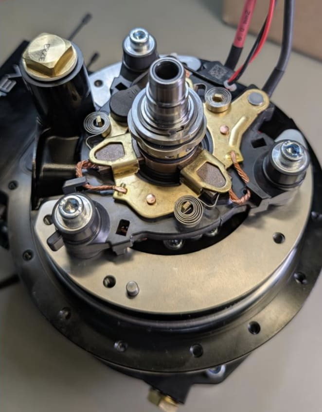 Exploded view of Torev axial flux motor components — rotor discs, stator, shaft, and housing — laid out on a workbench