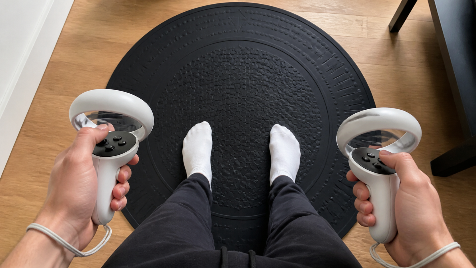 A first-person view of feet in socks on a black VR mat with Quest Pro controllers held below
