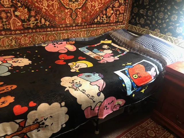 Cozy bed with cartoon blanket.