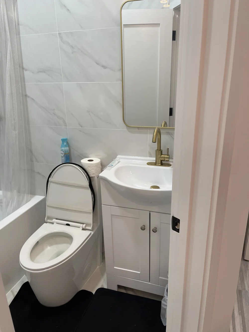 Compact modern bathroom with white fixtures.