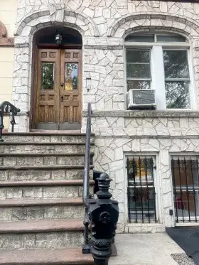 Ornate stone townhouse with steps.