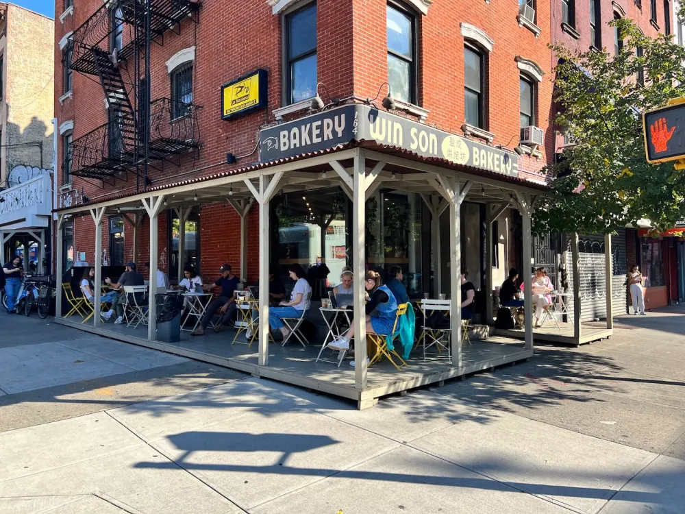 Corner bakery with outdoor seating.