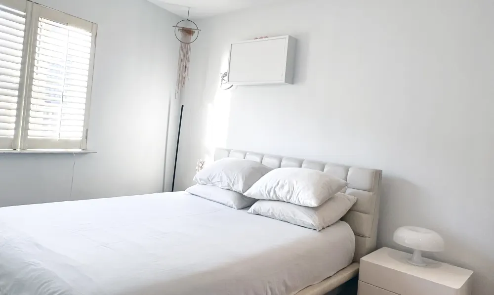 Minimalist bedroom with white decor.