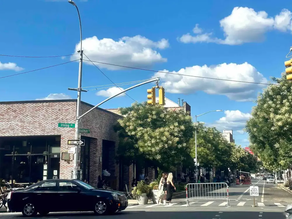 Intersection with brick buildings, trees.