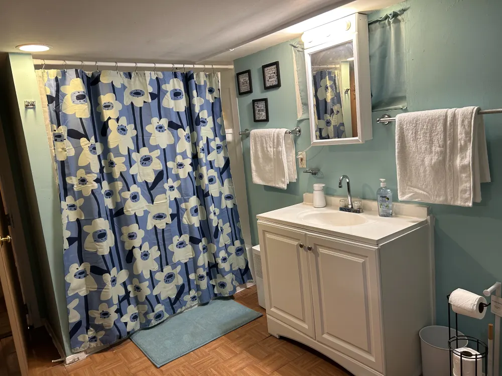 Colorful bathroom with floral curtain.