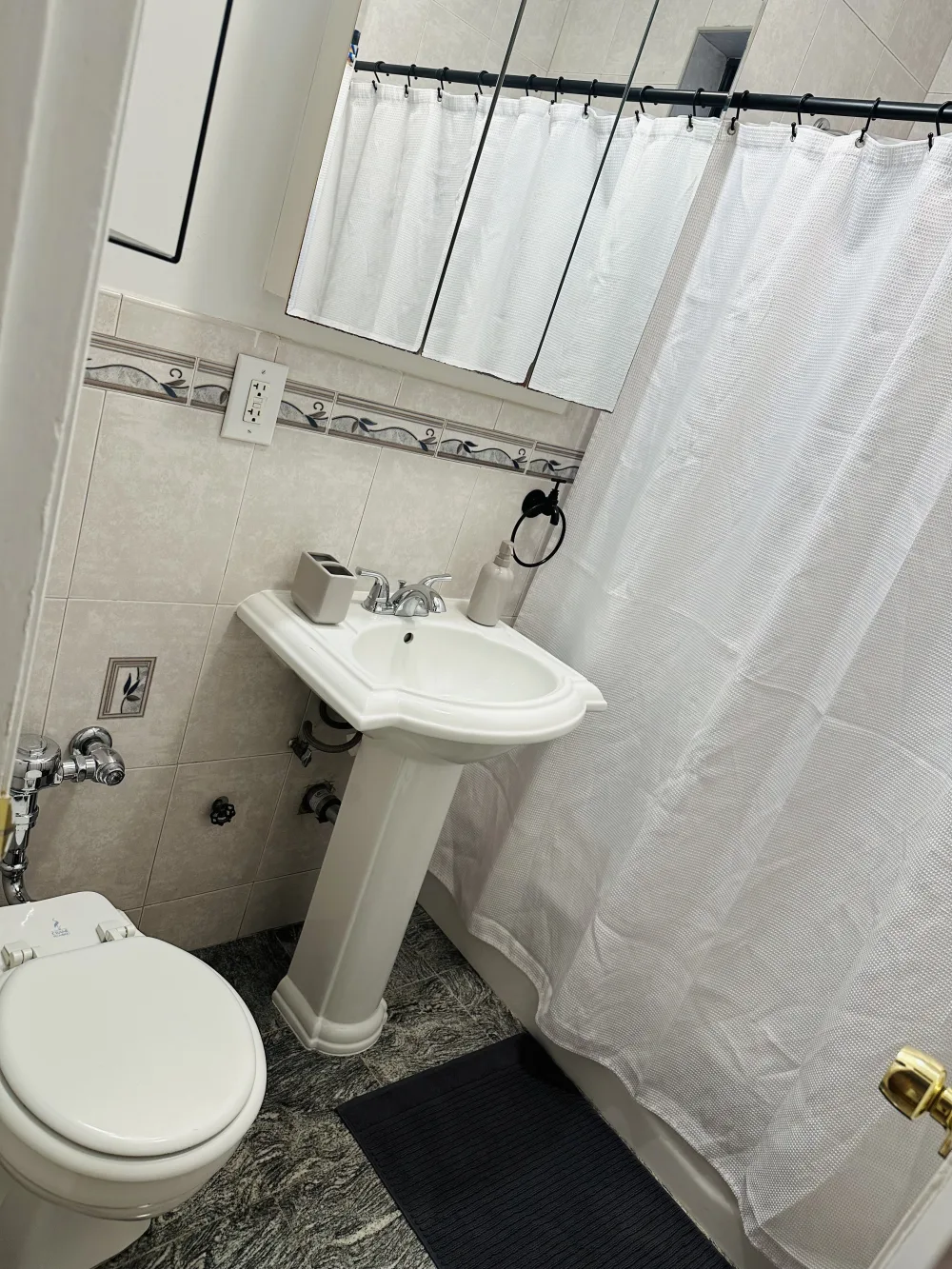 Compact bathroom with white fixtures.