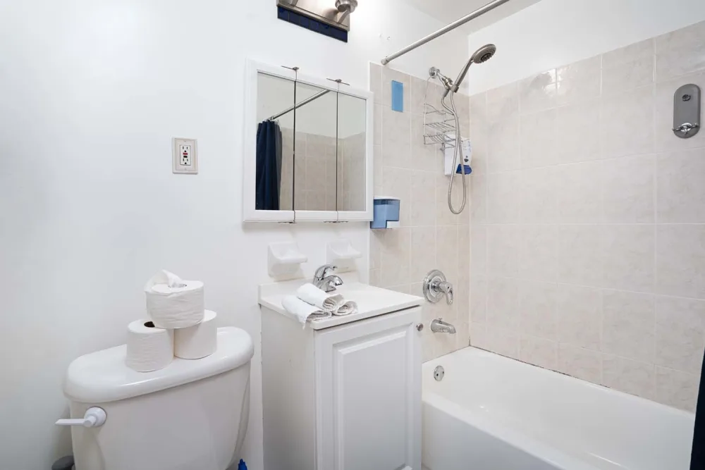 Clean, white tiled bathroom.