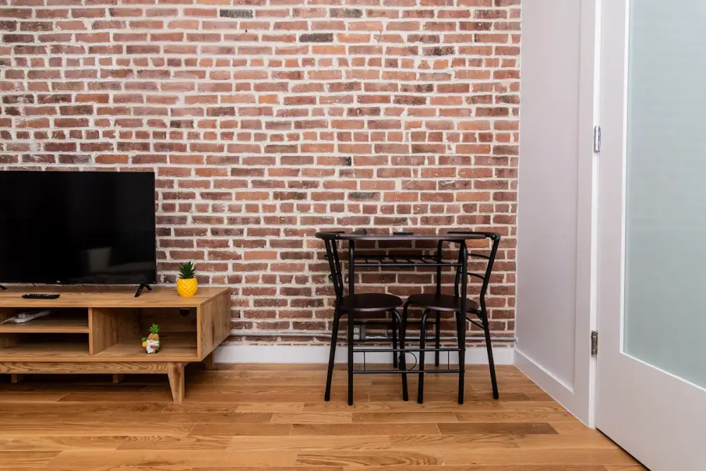 Brick wall, wood floor, cozy dining.