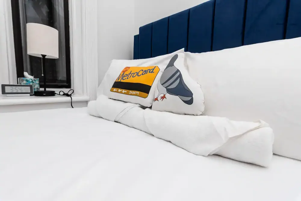 Cozy bed with NYC-themed pillow.