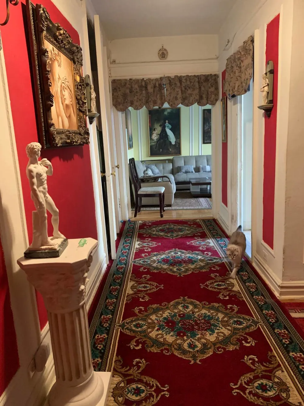 Hallway with red walls, artwork.