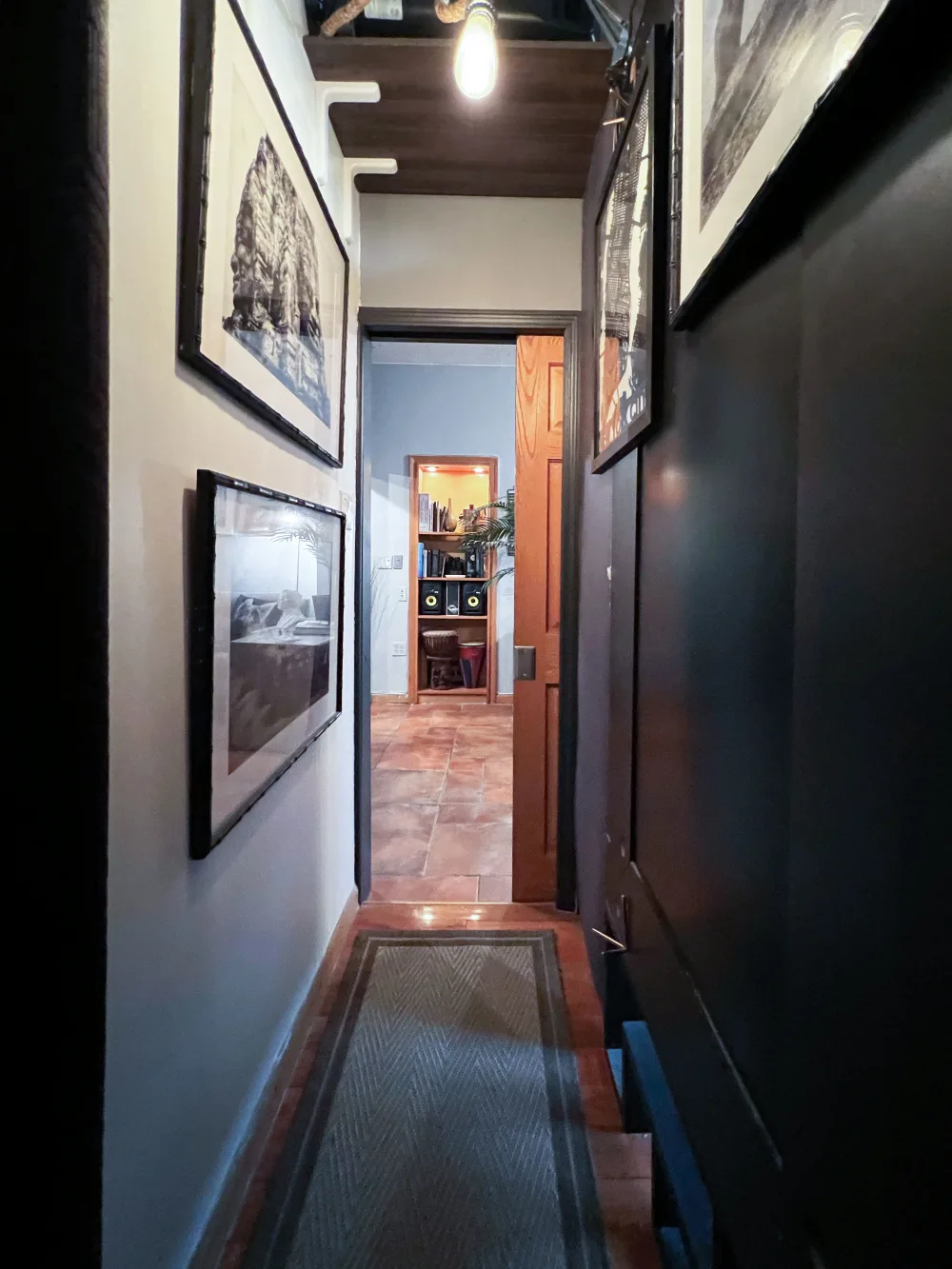 Narrow hallway with framed pictures.