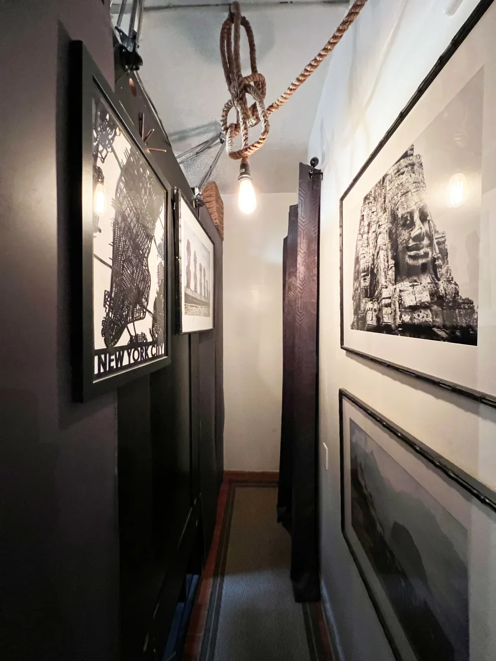 Narrow hallway with framed pictures.