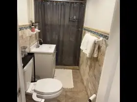 Compact bathroom with tiled walls.