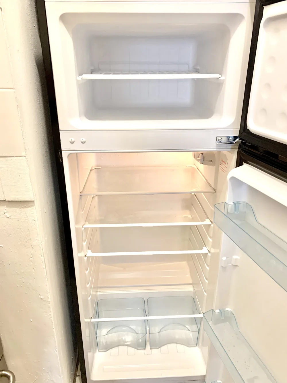 Empty refrigerator with open door.