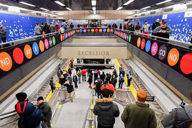 Busy subway station with colorful signage.