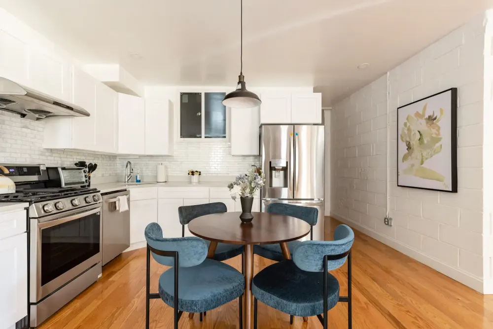Modern kitchen with blue chairs.