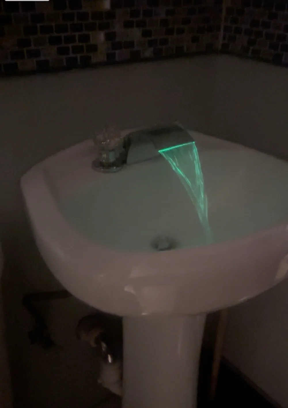 Illuminated bathroom faucet over sink
