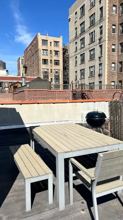 Rooftop seating area with buildings.