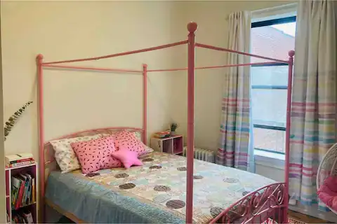 Bright bedroom with pink canopy bed.